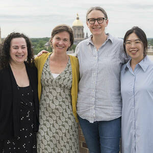 Athena in Action organizers Elizabeth Harman, Elisabeth Camp, Meghan Sullivan, and Sara Chan stand together on a balcony with the Dome and Basilica in the background.