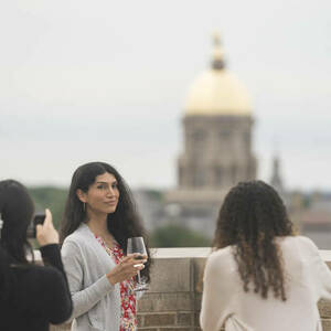 A group of Athena in Action participants on the balcony with the dome behind them