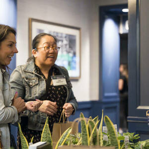 Two happy women with bags of plants.