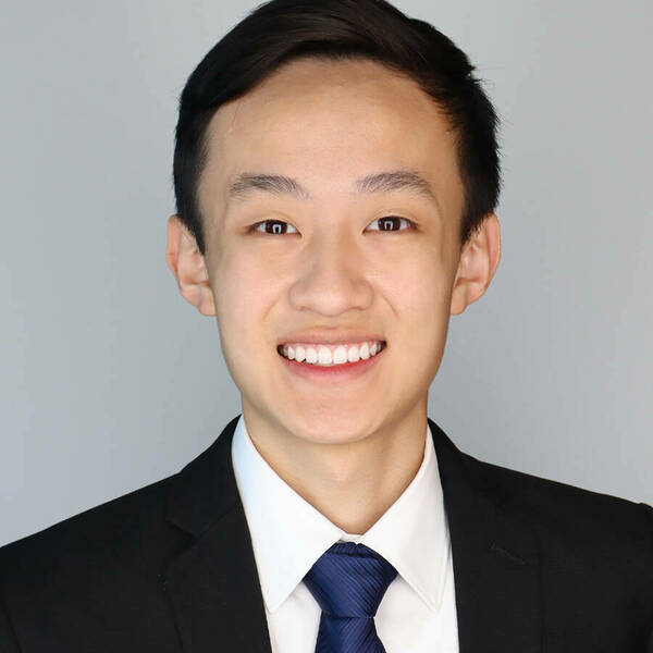 Portrait photo of Ethan Chiang, smiling student in black suit with blue tie and white shirt